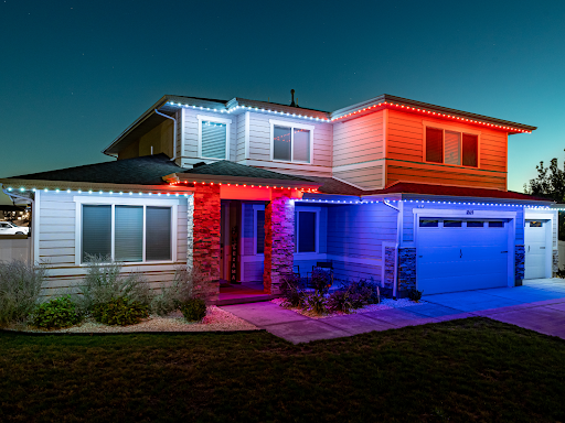 LED lights on a house. Blue lights over the garage and red and white lights over the windows.