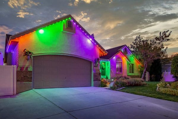 Halloween lighting on a home with green, orange and purple.